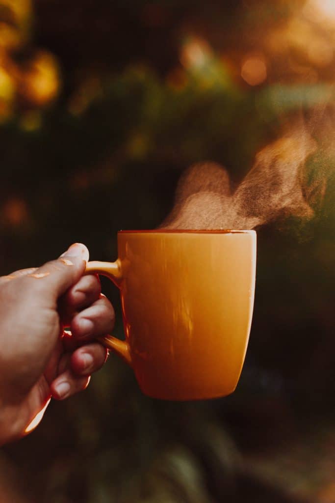 A picture of a hot cup of coffee with the morning breeze carrying away the steam.
