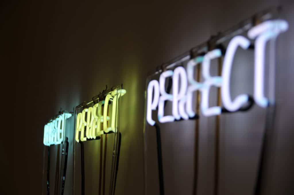 A picture of three neon signs that says "Perfect"