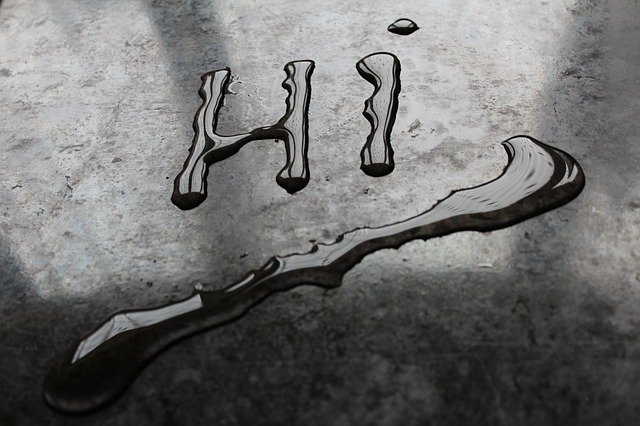 An image of the word "Hi" written in water on a counter top.